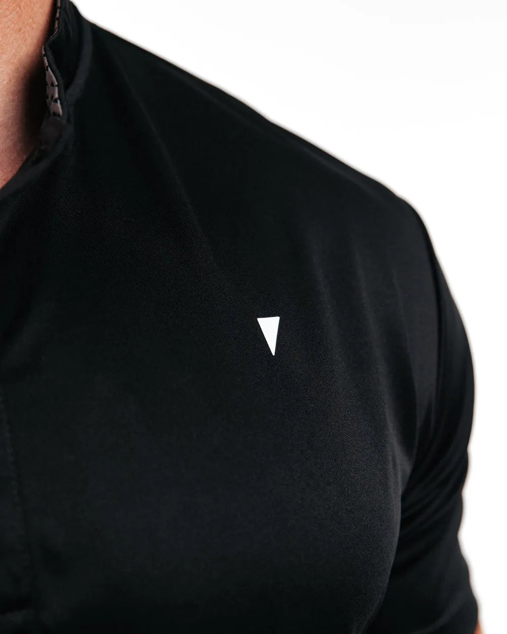 Black athletic shirt with a small white logo on a white background