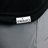 Close-up of a black polo with a 'Primo' logo on gray pants.