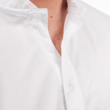Close-up of a person wearing a white golf polo with a mock collar.