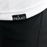 Close-up of a black garment with a Primo label on a white background