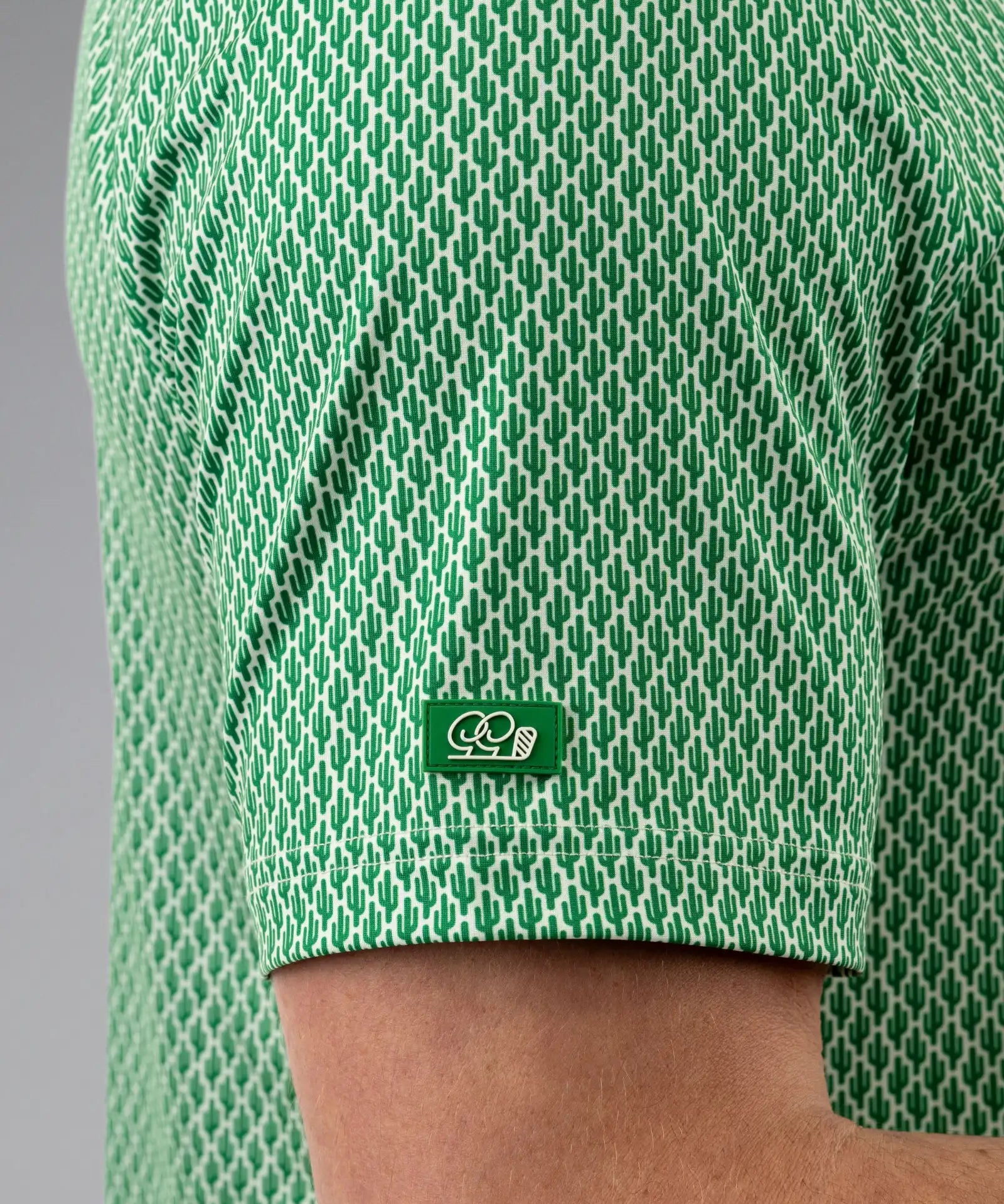Green patterned shirt with a logo on a gray background