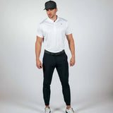 Man wearing a white polo shirt, black pants, and a cap on a white background