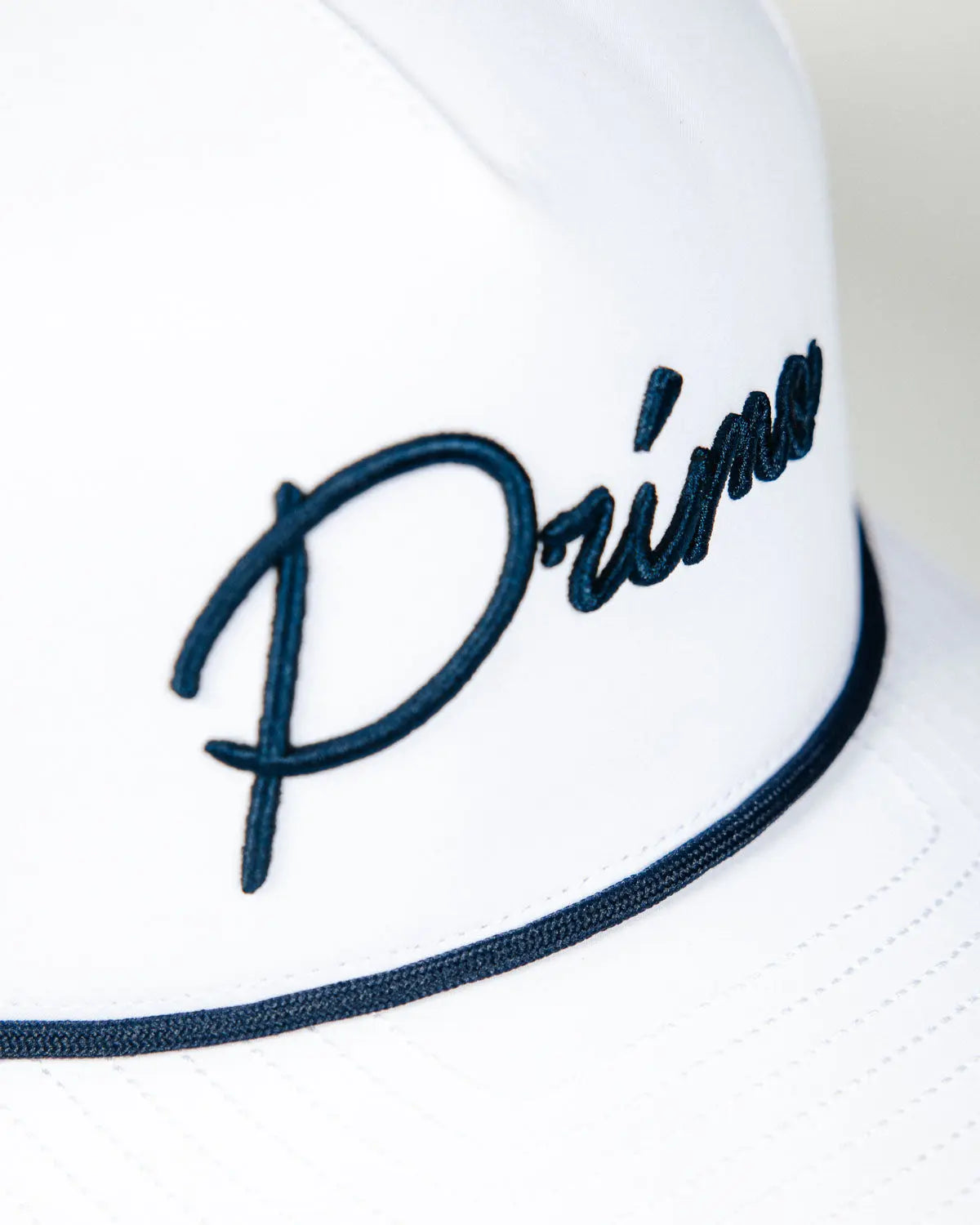 Side view of embroidered cursive logo on front of hat