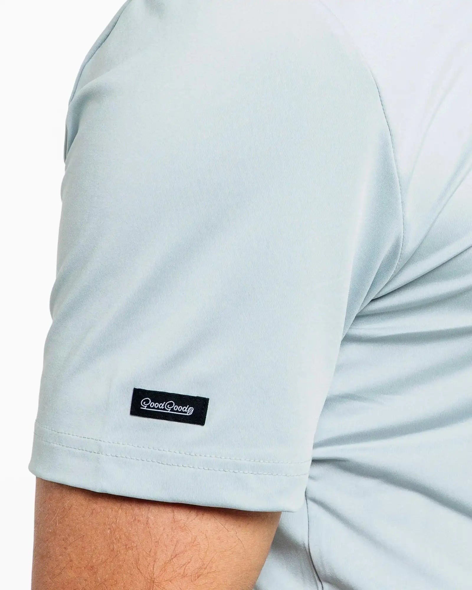 Light blue t-shirt with a brand logo on the sleeve against a white background
