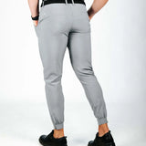 Person wearing gray jogger pants on a white background