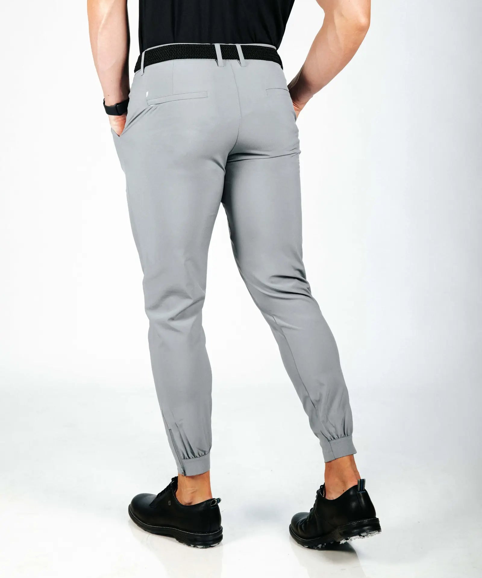 Person wearing gray jogger pants on a white background