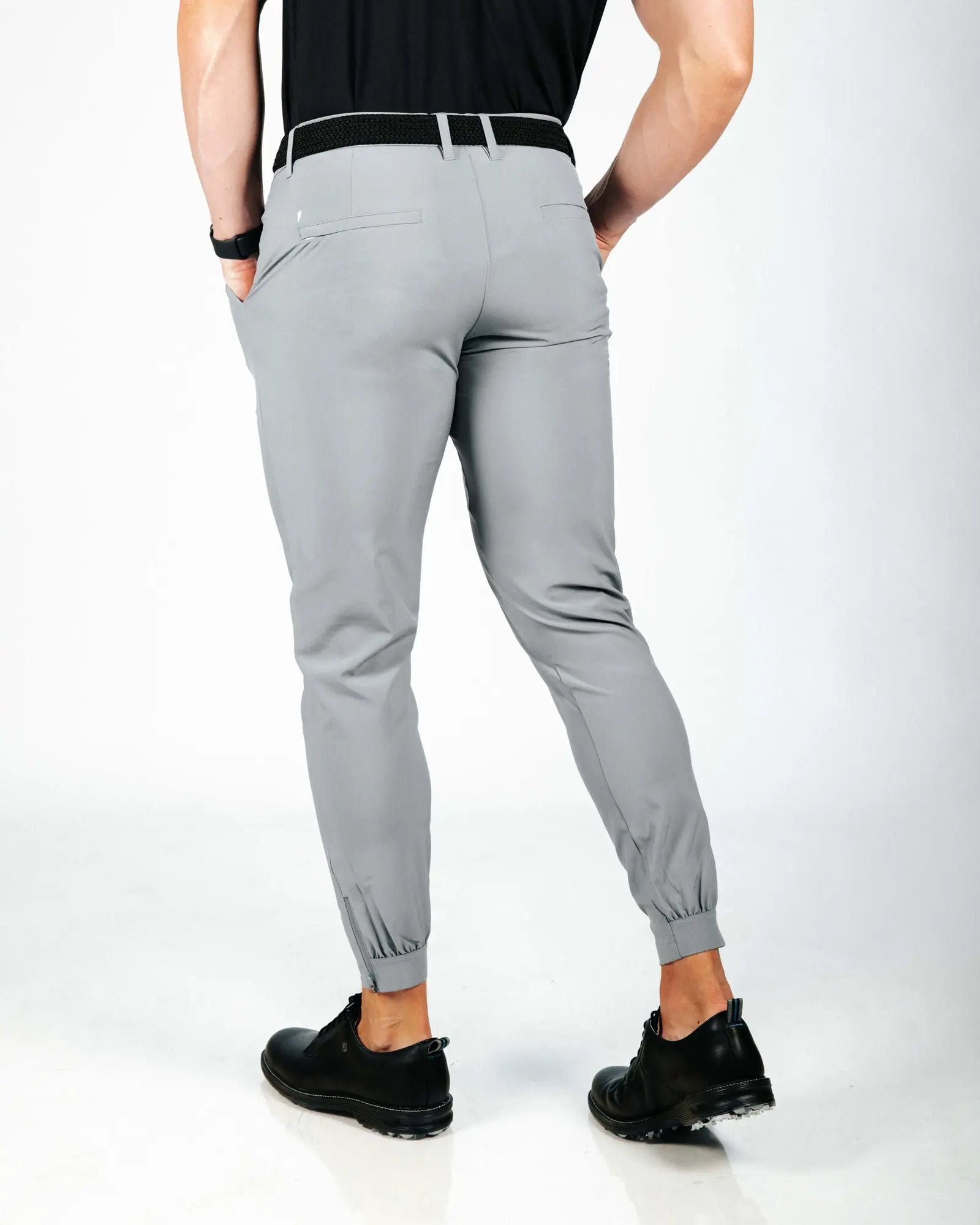 Person wearing gray jogger pants on a white background